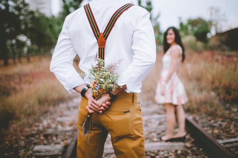 女性に花束を渡そうとしている男性の写真