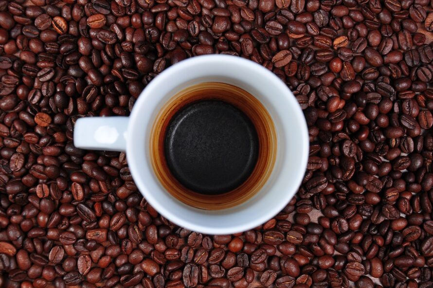 コーヒー豆の中心に置いてあるコーヒーカップの写真